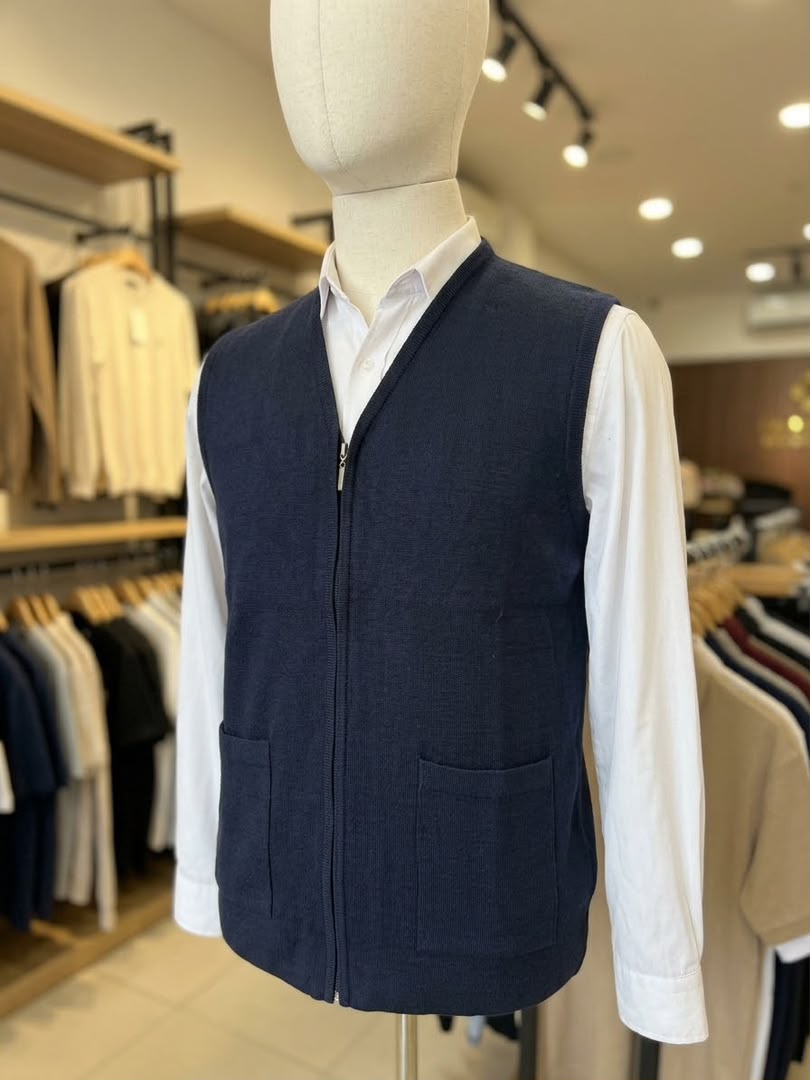 Gilet zippé bleu marine pour homme avec deux poches, porté sur une chemise blanche