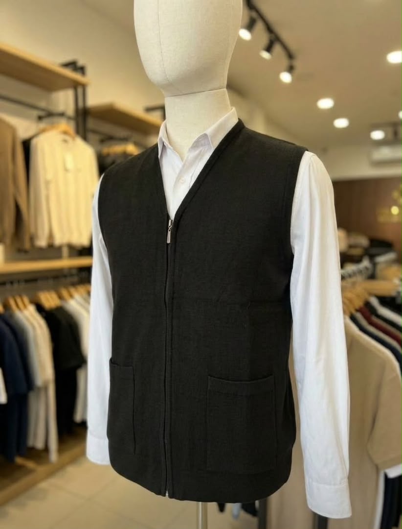 Gilet zippé noir pour homme avec deux poches, porté sur une chemise blanche